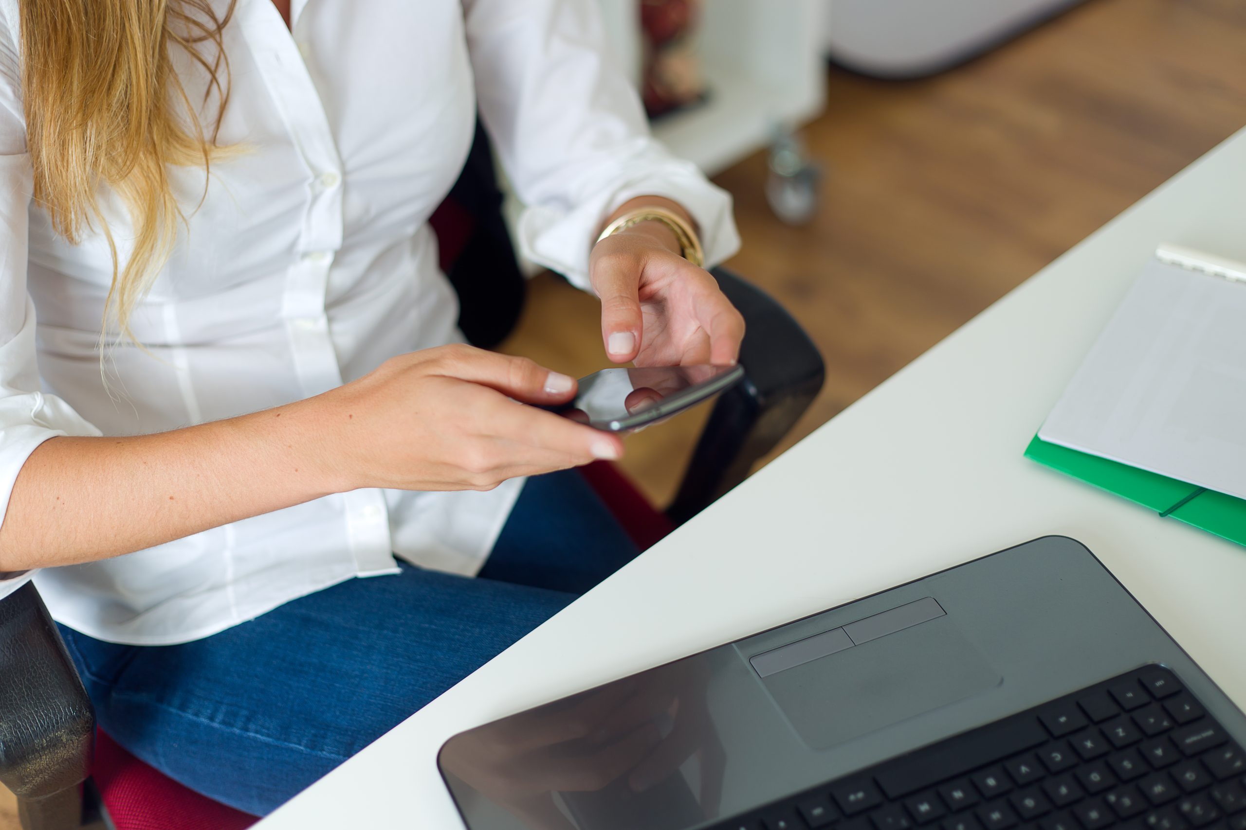 Portrait of business woman working with mobile phone in her office.